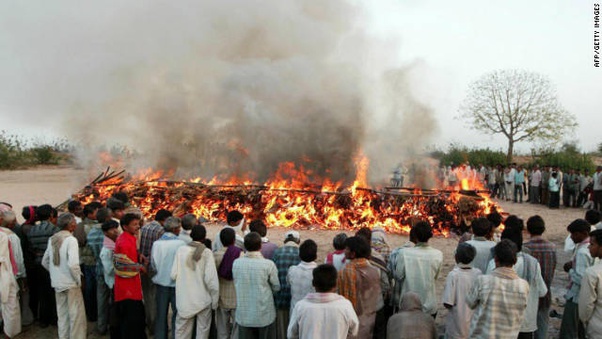 A large group of people gathered around a Balinese cremation fire