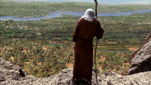 A robed figure with a staff looking out over a wide landscape